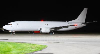 a photo of a Boeing 737 freighter aircraft, viewed at night, sitting on the tarmac.