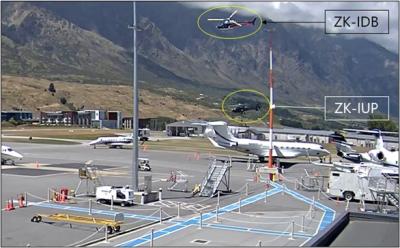 Photo across Queenstown Airport's Southern Apron with the two helicopters airborne in the middle distance
