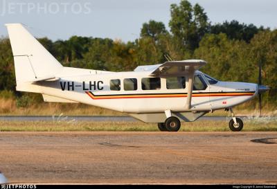 The accident aircraft, a Gippsland GA8 Airvan, photographed in 2022. (c) Jarrod Swanwick via JetPhotos A Gippsland GA8 Airvan, registration VH-LHC, viewed from the starboard side. It is on the ground with engine running and propeller turning. The aircraft has high wings, fixed tricycle landing gear, and six side windows. Painted white with a thin red, yellow, and black cheatline running along the fuselage. Beyond the tarmac, in the background is tick foliage of bushes and trees.