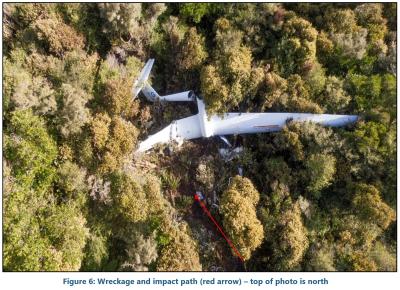 Figure 6 from the final report. The glider wreckage is shown in an aerial photo of the accident site. The wings are embedded in trees and bushes on the mountainside. The tail section has broken off. The cockpit structure is also broken off and in numerous pieces. 