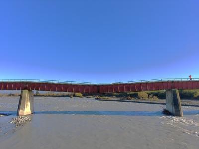Photo of a rail bridge, side view, showing two supporting concrete piers, in the middle of the gap between them, there should be a third pier, but it is missing. In its place, the bridge has a shallow but clearly noticeable  'V' shaped sag.