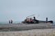 Photo - TAIC investigators inspect the helicopter wreckage on the beach 