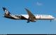 Air New Zealand Boeing 787-9 Dreamliner, registration ZK-NZR, in black and white koru and fern livery, flying with landing gear extended against a clear blue sky