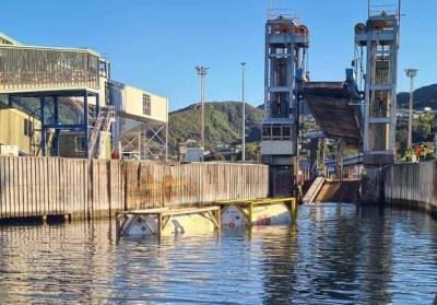 The wagon half-submerged. Loco is on harbour bottom. Photo | Supplied Photo shows the ferry berth at Picton. In the foreground, a freight wagon (comprising two large gas bottles) floats in the harbour. The locomotive is out of view submerged. In the background is the ferry embarkation linkspan apparrently broken.