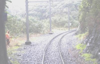 still image from Forward-looking CCTV camera on train, taken at the point just before ehte train emerges from tunnel. The track workers are seen just outside the tunnel mouth, to one side of the tracks