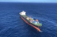 Shiling after the second incident. Photo: Nelson Marlborough rescue helicopter Aerial view of the container ship Shiling adrift in open ocean following a machinery failure during its second incident in 2023. The vessel is heavily laden with multi-coloured shipping containers stacked on deck. The bow is visibly trimmed low, and the ship appears to be listing slightly to port. Sea state is moderate under clear skies, with the New Zealand coastline faintly visible on the horizon. Image captured by the Nelson Marlborough Rescue Helicopter during a response operation