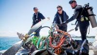 Investigator & diver examine retrieved plane wreckage Investigator & diver examine retrieved plane wreckage