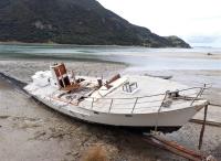 The wrecked hull of the Enchanter was hauled up on to a Northland beach for TAIC investigators to inspect Enchanter hull on beach