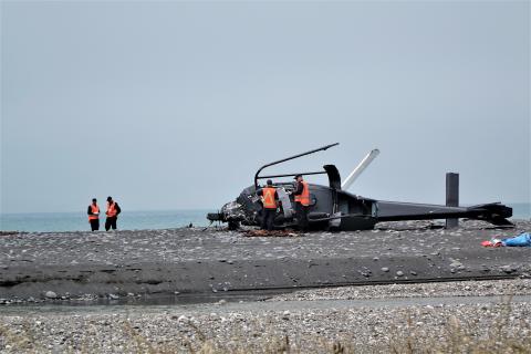 TAIC investigators inspect the helicopter wreckage on the beach | Photo: RNZ- Tracy Neal